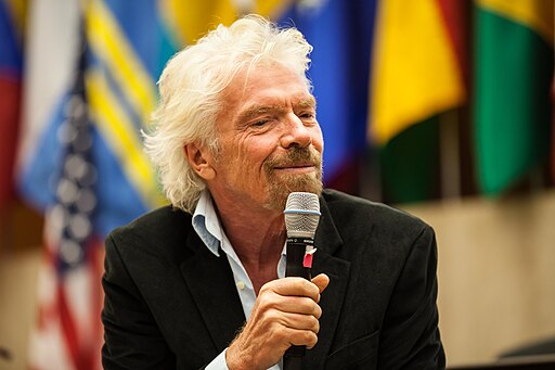 Sir Richard Branson at a conference with microphone.
